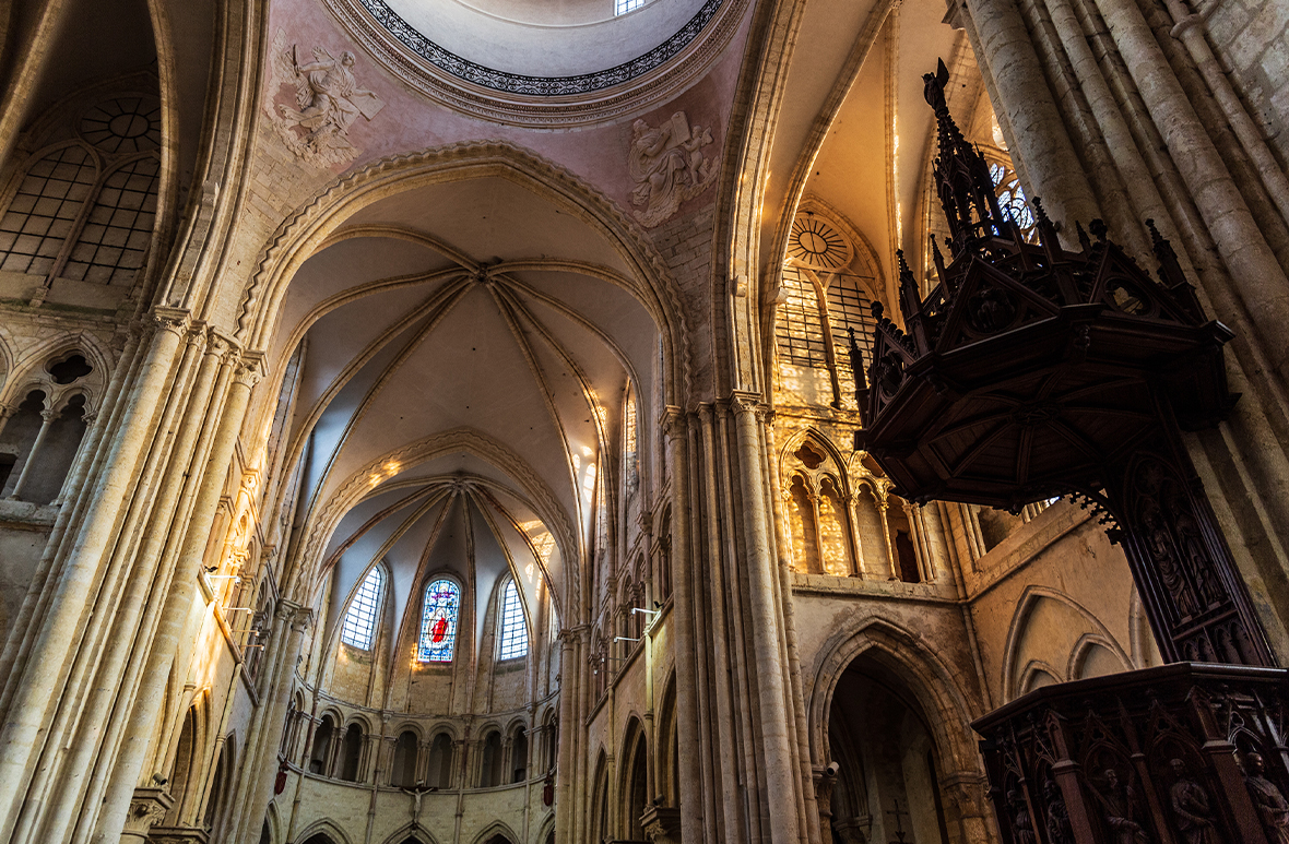 Inside a large ornate church with Gothic and medieval influences in the archways and stained-glass windows